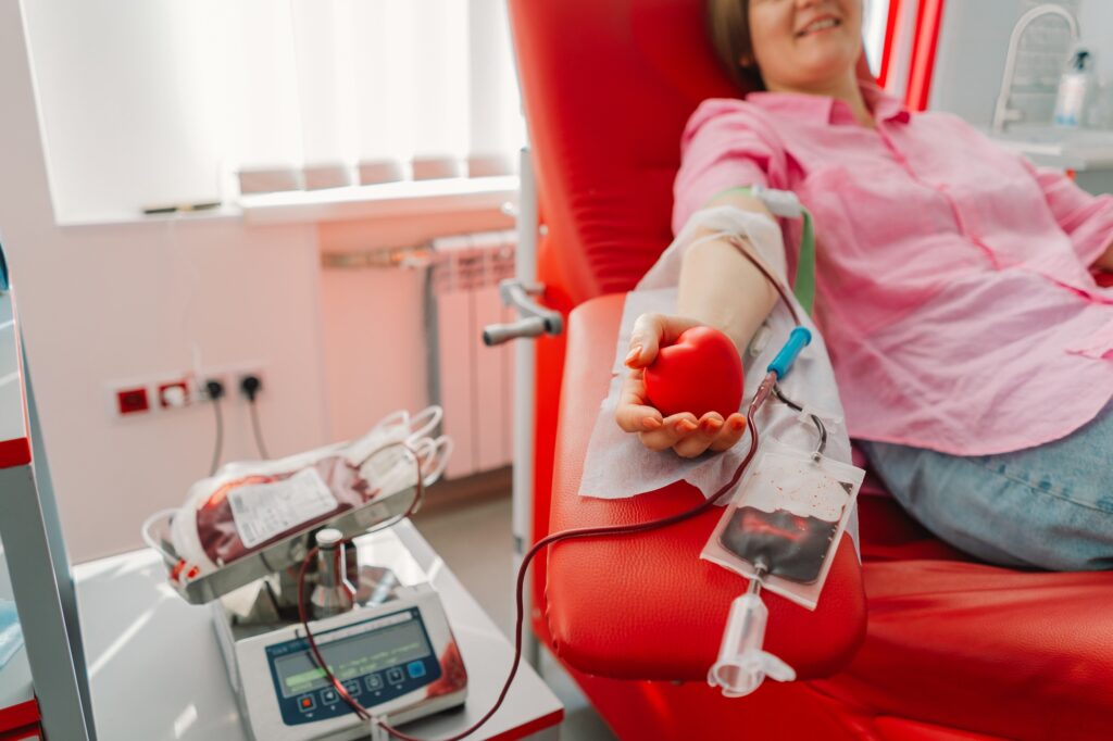 Young woman making blood donation in hospital. Blood donation.